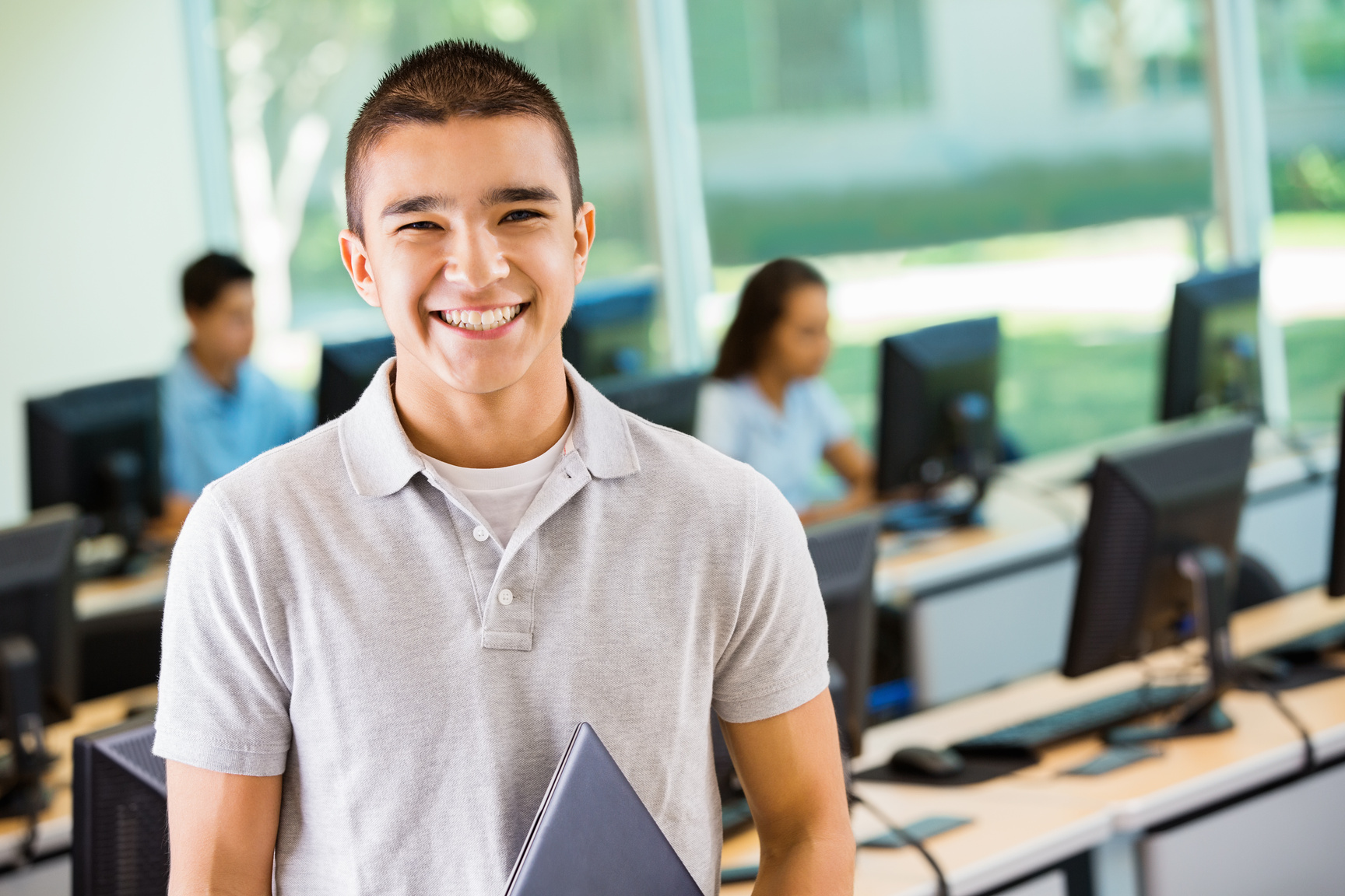 Teen boy smiling in high school computer lab